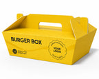 A bright yellow cardboard burger box with built-in handles, printed with the words 'BURGER BOX' and a circular badge reading 'PREMIUM PACKAGING YOUR LOGO MADE TO SERVE,' shown on a clean white background.