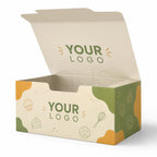 An open custom bakery or gift box with a cream-colored interior and exterior decorated with green and orange abstract shapes and food illustrations like cupcakes, a cake slice, a whisk, and a donut. The words 'YOUR LOGO' are printed on the inside lid and front panel.