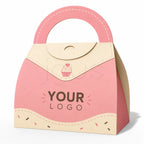 A pink and beige paper gift bag or packaging box with a rounded top handle, featuring a cupcake illustration and the text 'YOUR LOGO' on the front, shown on a white background.