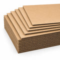 A stack of brown corrugated cardboard sheets showing the inner wavy cardboard layers, photographed on a clean white background.