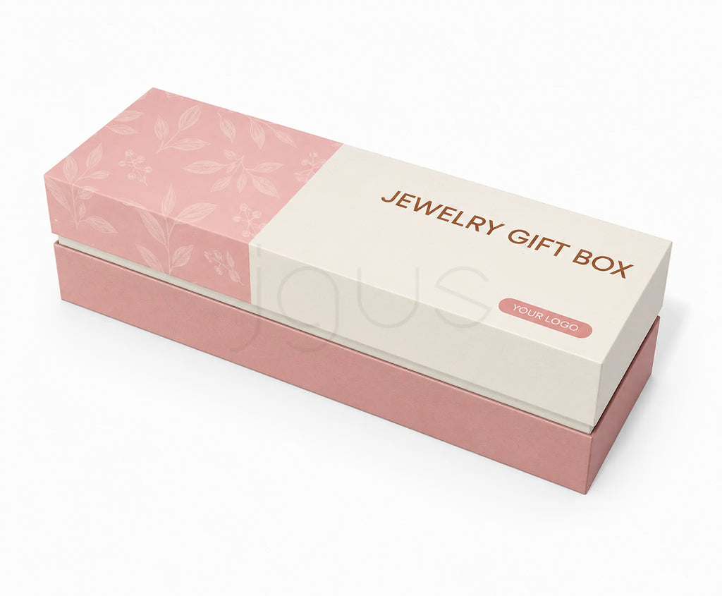 A rectangular jewelry gift box shown at an angle on a light gray background. The top lid is cream with a pink floral pattern on the left and the words 'JEWELRY GIFT BOX' in rose-gold text, plus a small 'YOUR LOGO' label.