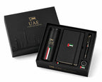 A luxury black gift set for the UAE, featuring a matching black presentation box with gold lettering and a black travel tumbler, notebook, pen, and ring set inside, decorated with the UAE flag colors.